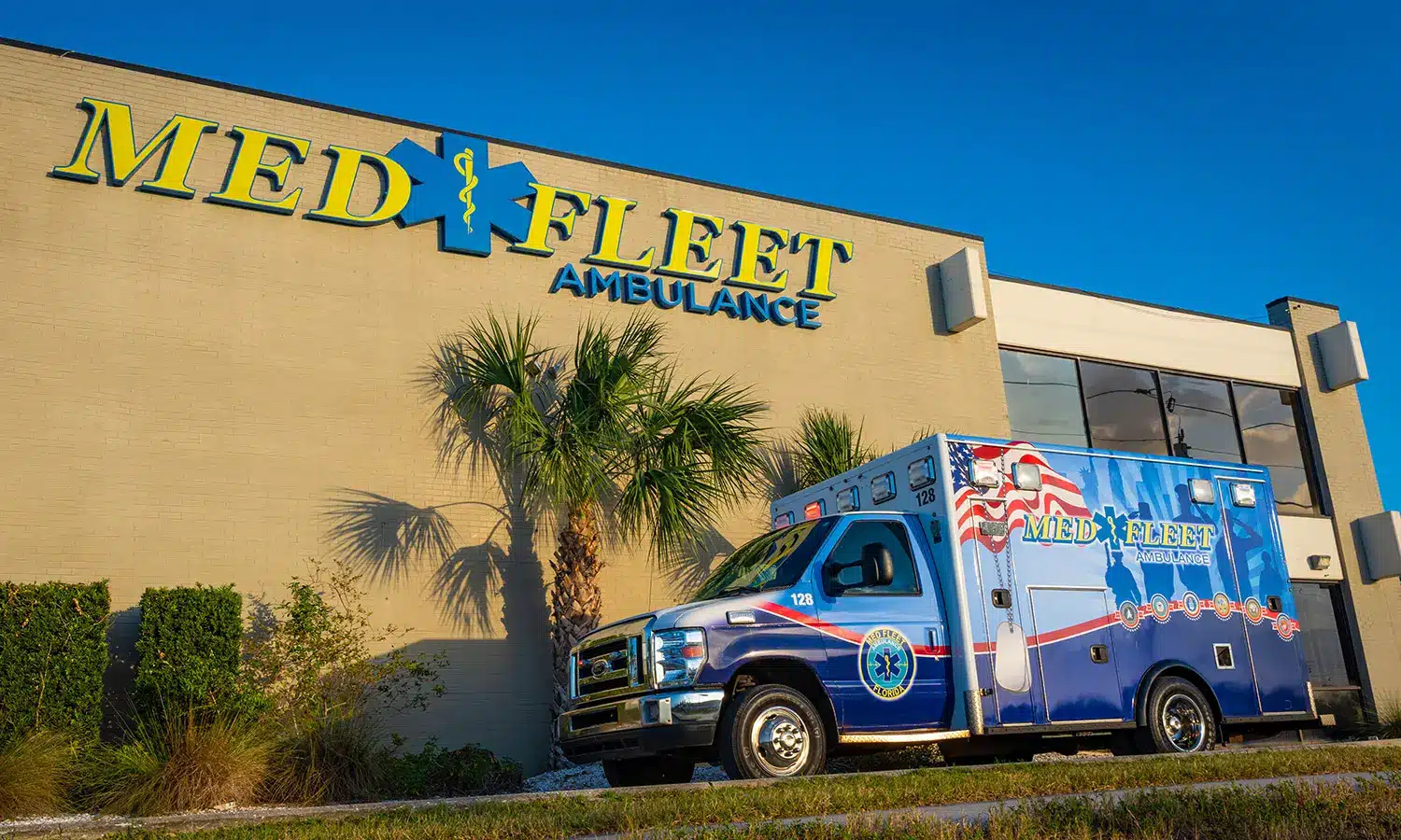 MedFleet ambulance parked in front of a MedFleet building with palm trees and blue sky